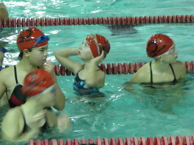 In this picture I can observe some children in the swimming pool. All of them are wearing caps and...