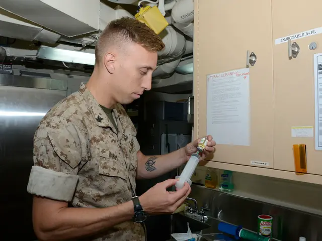 In this image I can see a person wearing grey and brown colored shirt is standing and holding a...