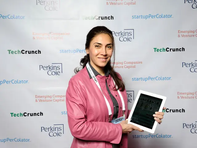 In this picture, we see a woman in the pink jacket is standing. She is wearing an ID card and she...