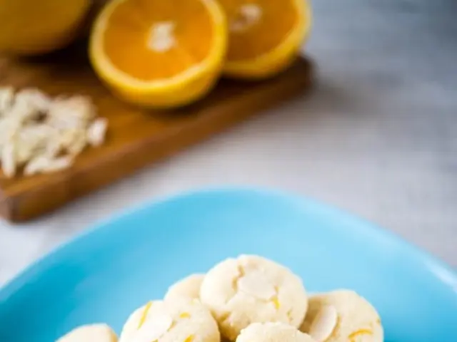 In the center of the picture there are biscuits in a blue color plate. At the top there are fruits...