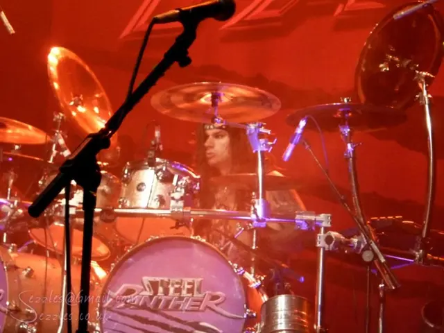 In the image there is a music band,a person is playing the band and around that area there is a lot...