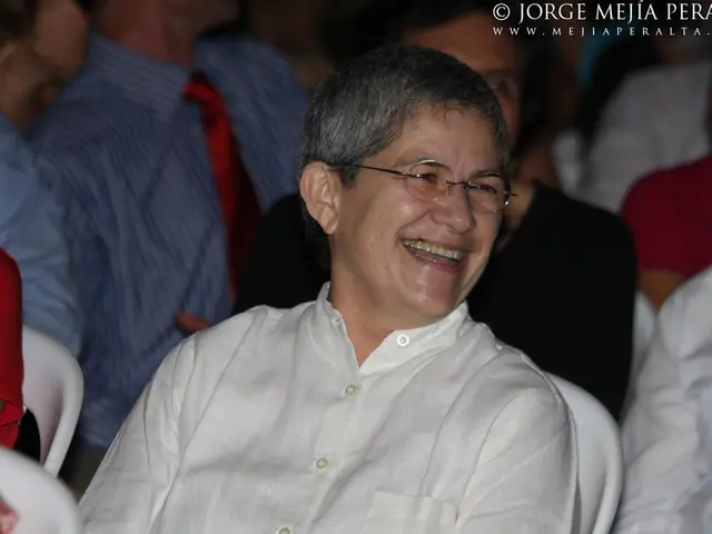 In this image there are a few people sitting on the chairs. In the top right there is text on the...