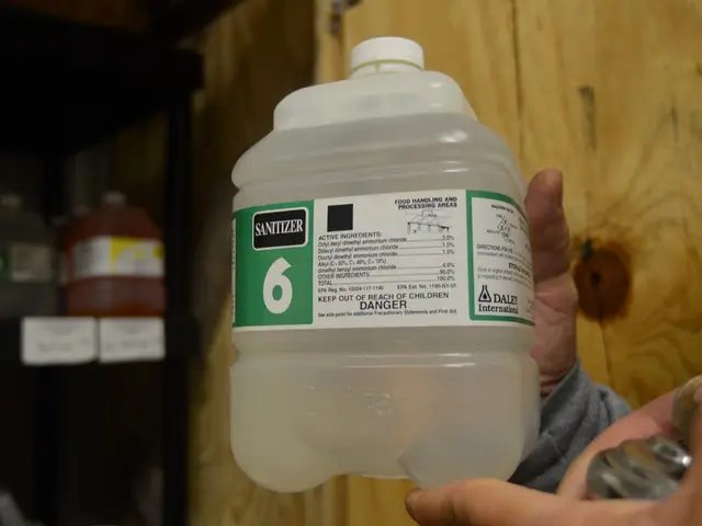 This picture shows a man holds a bottle of sanitizer
