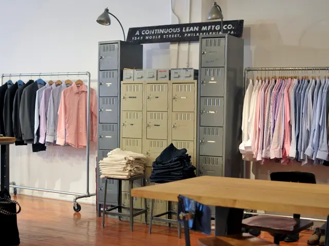 This image consists of a room. In which there are many shirts hanged to a stand. In the middle,...